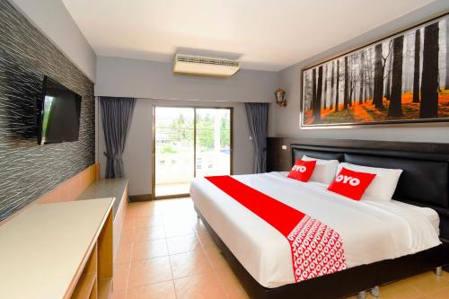 1 dormitorio con 1 cama grande con almohadas rojas en OYO 765 Pom Pom Residence, en Hua Hin