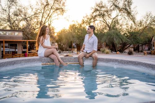 a man and a woman sitting in a swimming pool at Tantakuy Eco Experience Hotel in La Huaica