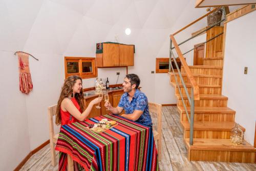 a man and woman sitting at a table in a kitchen at Tantakuy Eco Experience Hotel in La Huaica