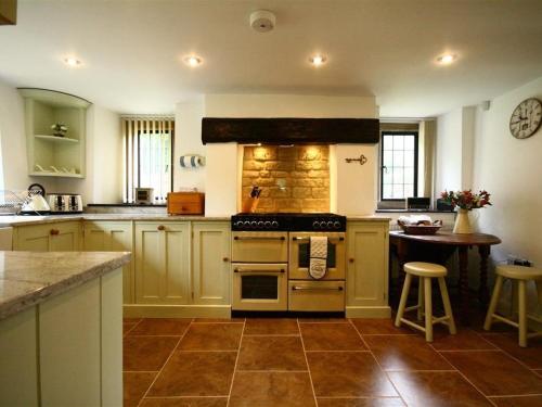 a kitchen with a stove and a table in it at Tumbledown in Broadway