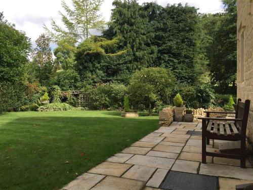 a garden with a bench and a grass yard at Tumbledown in Broadway