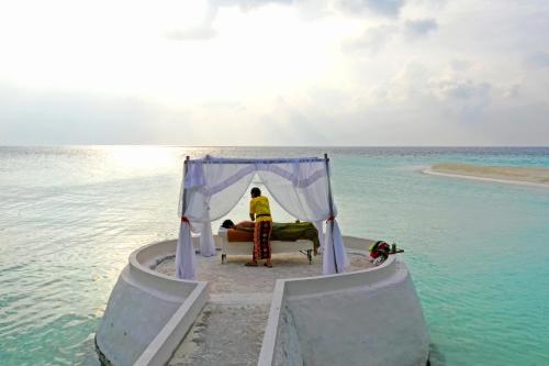 a man sitting in a bed in the middle of the ocean at Eriyadu Island Resort in Reethi Rah