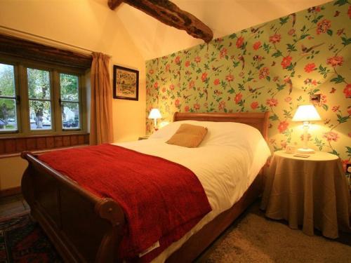 バーフォードにあるTannery Cottageの花柄の壁紙を用いたベッドルーム1室(大型ベッド1台付)