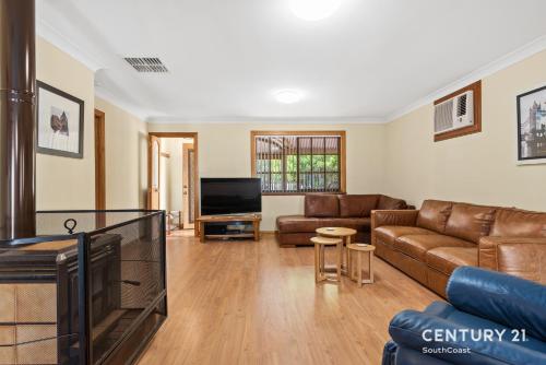 a living room with a couch and a tv at Reef & Vines - Port Noarlunga - C21 SouthCoast Holidays in Port Noarlunga