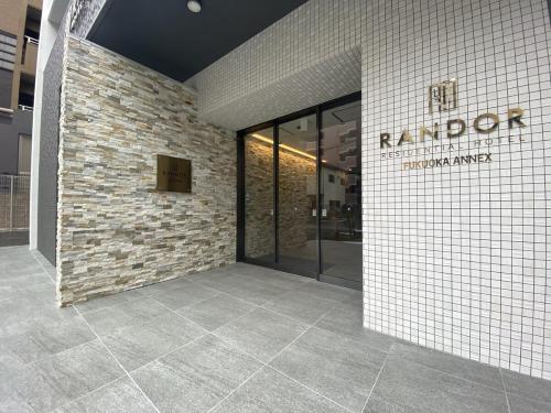 a lobby of a building with a brick wall at Randor Residential Hotel Fukuoka Annex in Fukuoka
