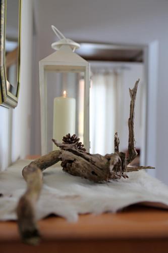 a candle and a branch on a table next to a mirror at Mühlradl Apartments Gosau in Gosau