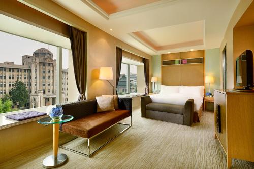 a hotel room with a bed and a couch and a window at Sofitel Xi'an On Renmin Square in Xi'an