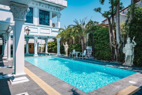 a swimming pool in front of a house at Amazing Pool Villas in Pattaya