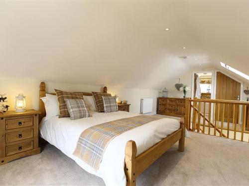 a bedroom with a large bed and a staircase at Old Groom's Cottage in Witney