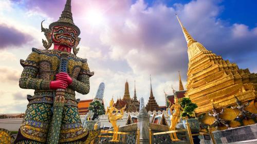 a statue standing in front of a temple at Holiday Inn Bangkok by IHG in Bangkok