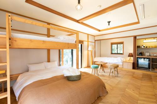1 dormitorio con 2 literas y mesa en Riverside Lodge, en Matsuno-cho