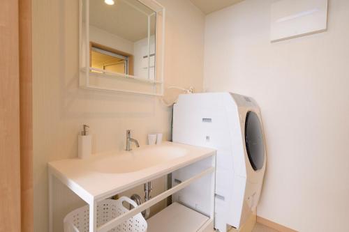 a bathroom with a sink and a refrigerator at BEYOND HOTEL Takayama 3rd in Takayama
