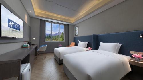 a hotel room with two beds and a television at Holiday Inn Express Beijing Badaling by IHG in Yanqing