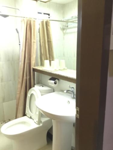 a bathroom with a toilet and a sink at Delle Suites in General Santos