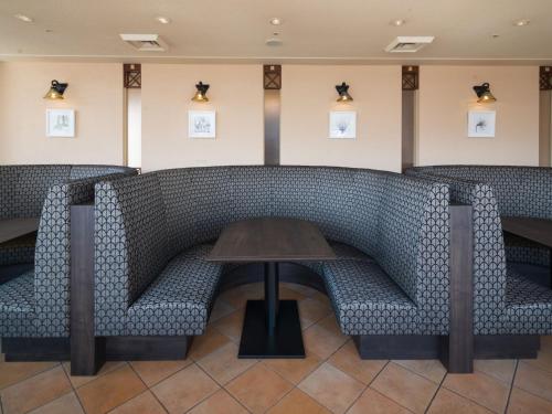 a row of chairs and a table in a room at ART HOTEL Aomori in Aomori