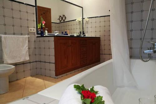 een badkamer met een bad, een wastafel en een spiegel bij Casa Es Mercat in Sóller