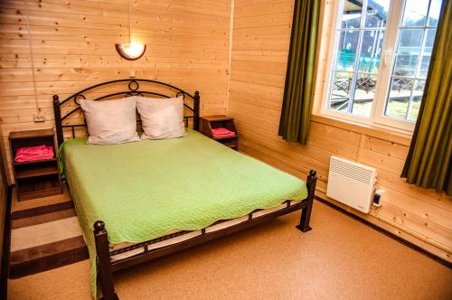 ペレスラヴリ・ザレスキーにあるDom na beregu ozera Pleshcheevo 1のベッドルーム1室(緑のシーツが敷かれたベッド1台、窓付)