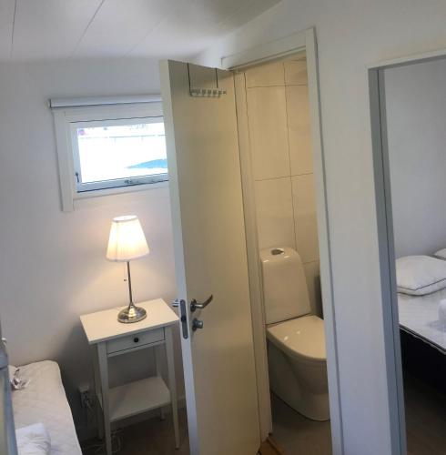 a bathroom with a toilet and a lamp on a table at Trelleborg Strand in Trelleborg