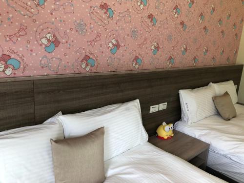 a hotel room with two beds and a stuffed animal on a table at 太魯閣惠宇民宿 in Xincheng