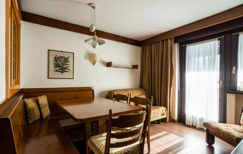 a dining room with a table and chairs in a room at Residence Lastei in San Martino di Castrozza