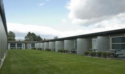 a building with a green lawn in front of it at Brighton Hotel Motel in Pontville