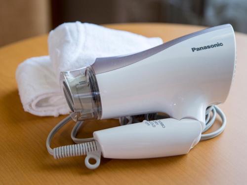 a white hair dryer sitting on top of a table at Hotel Monterey Kobe in Kobe