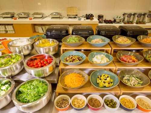 a bunch of bowls of food on shelves in a kitchen at Hotel Monterey Kobe in Kobe