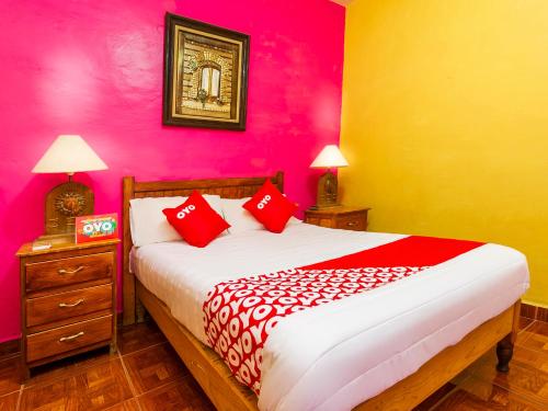 1 dormitorio con 1 cama con paredes rojas y amarillas en OYO Posada De Los Angeles, Pátzcuaro, en Pátzcuaro