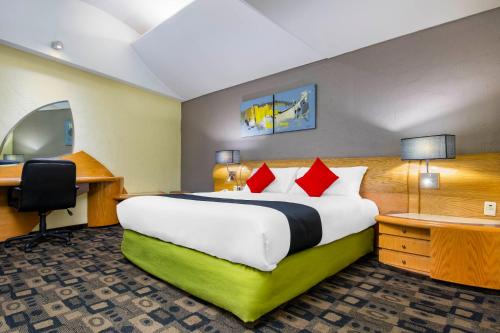 a hotel room with a large bed and a desk at Hotel Mandarin Carton in Mexico City