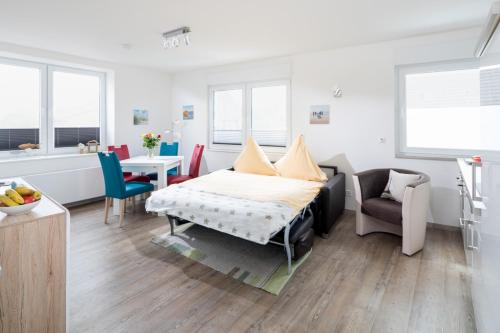 ein Schlafzimmer mit einem Bett, einem Tisch und Stühlen in der Unterkunft Haus Inselzeit in Norderney