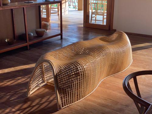 a wicker bench sitting on the floor of a room at Balian Prana in Selemadeg