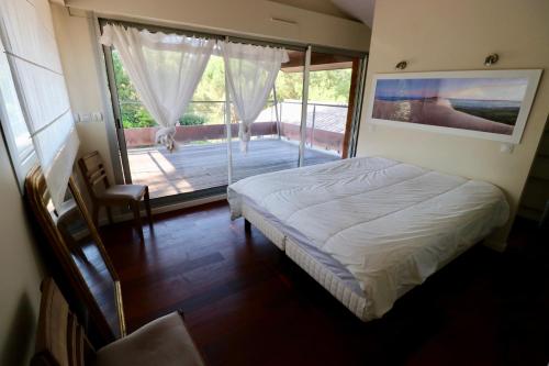 - une chambre avec un lit et une grande fenêtre avec un balcon dans l'établissement Exclusive Villa with large terrace and pool, high standard beaches in walking distance, à Lège-Cap-Ferret