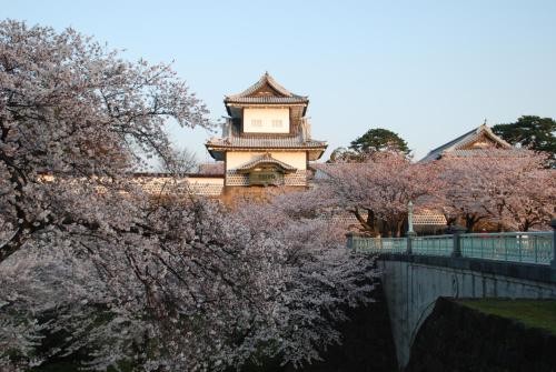 a building with a tower in the middle of trees at Town Hotel 41 in Kanazawa