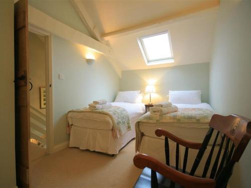Habitación pequeña con 2 camas y ventana en Cider Press Cottage en Priston