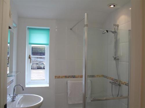 uma casa de banho com um chuveiro e um lavatório. em The Milking Parlour em Shaftesbury