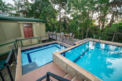 a swimming pool with a deck and a house at Spring Villas Kandy in Kandy