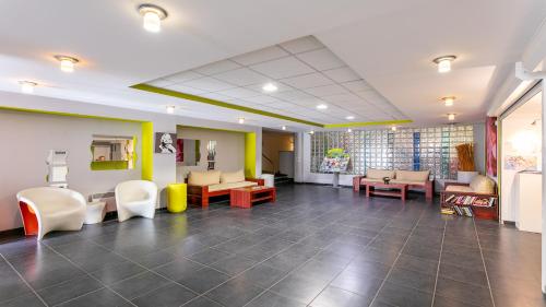 a waiting room at a hospital with chairs and tables at Vacancéole - Résidence Le Saint Clair in Cap d'Agde