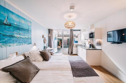 ein Wohnzimmer mit einem großen Bett und eine Küche in der Unterkunft West 7 in Zandvoort
