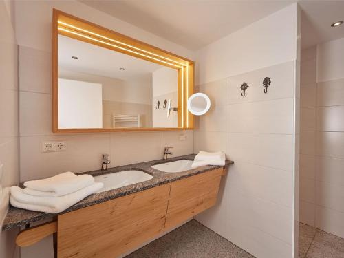 a bathroom with a sink and a mirror at Brunnwirt ESSEN & WOHNEN in Fuschl am See