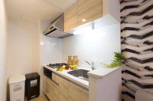 Hotel ONE'S RESIDENCE في سابورو: مطبخ صغير مع حوض ومكتب