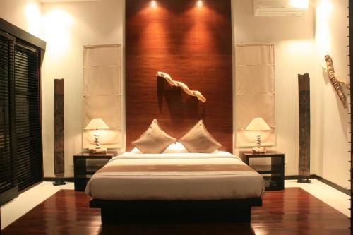 a bedroom with a large bed and two lamps at Katala Suites and Villas in Sanur