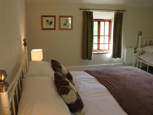 a bedroom with a bed and a window at Little Millend in Coleford