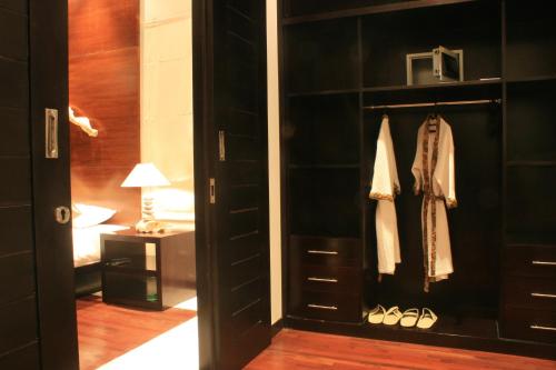 a room with a black closet with shoes and a lamp at Katala Suites and Villas in Sanur