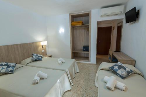 a hotel room with two beds and a television at Hostal Mayol in Santa Eularia des Riu