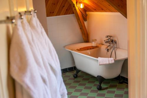 a bathroom with a bath tub and a sink at B&B De Postoari Terschelling in Hoorn