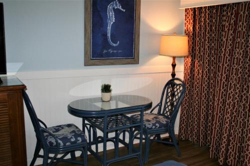 a table with two chairs and a table with a plant on it at Avenue Inn & Spa in Rehoboth Beach