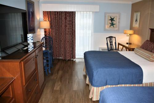 a hotel room with a bed and a flat screen tv at Avenue Inn & Spa in Rehoboth Beach