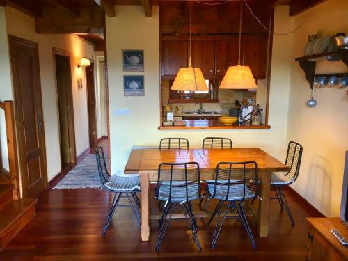 a dining room with a wooden table and chairs at Casa adosada con piscina en Agoustrina in Angoustrine