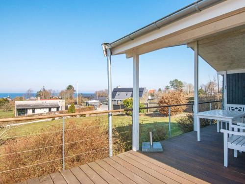 a deck with a picnic table and a view of a field at 6 person holiday home in Alling bro in Rygård Strand