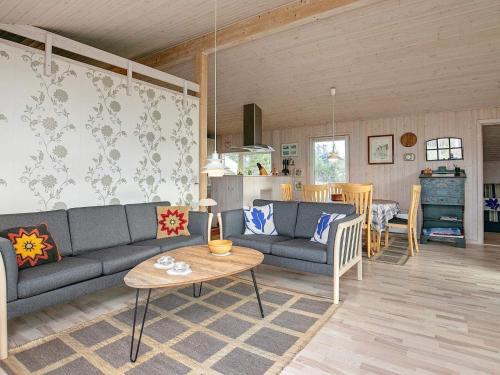 ein Wohnzimmer mit einem Sofa und einem Tisch in der Unterkunft 7 person holiday home in Hj rring in Hjørring
